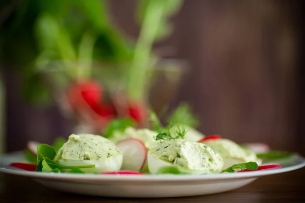 Boiled stuffed eggs with green cheese filling with arugula leaves and radish — Stock Photo, Image