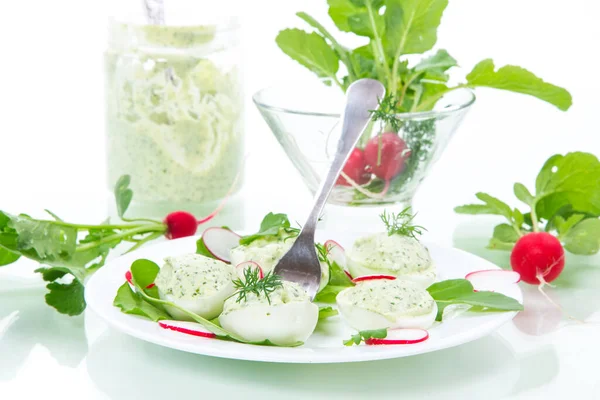 Boiled stuffed eggs with green cheese filling with arugula leaves and radish — Stock Photo, Image