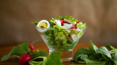 Bahar salatası roka, haşlanmış yumurta, taze turp, cam kasede salata yaprakları.