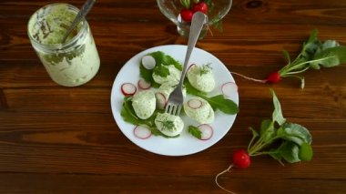 Roka yaprakları ve turpla doldurulmuş yeşil peynirli doldurulmuş yumurta.