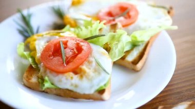 Yumurtalı kızarmış ekmek, salata, tabakta domates.