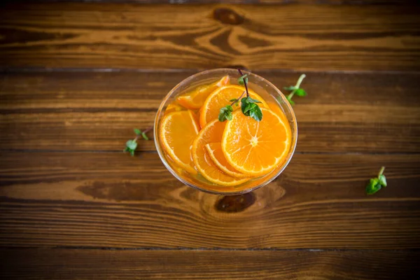 甜甜的橘子糖浆放在木制桌子上的玻璃碗里 — 图库照片