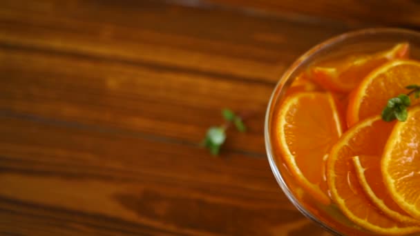 Jarabe de mandarina en un recipiente de vidrio sobre una mesa de madera — Vídeo de stock