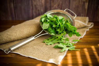 Arugula ahşap bir masada kevgir gibi.