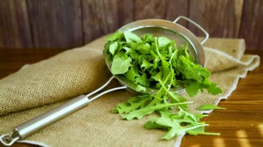 Arugula ahşap bir masada kevgir gibi.