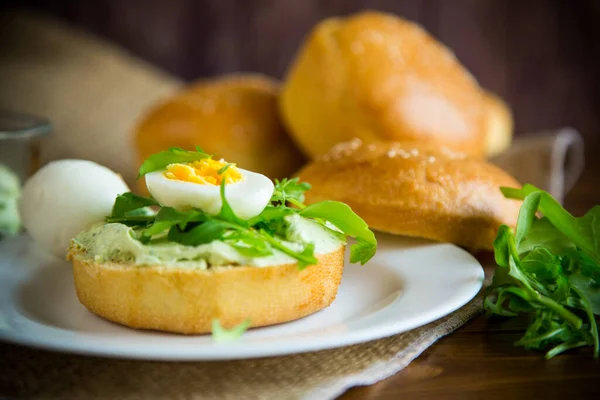 Hausgemachtes Brötchen Mit Käseaufstrich Frischem Rucola Und Gekochtem Einem Teller — Stockfoto