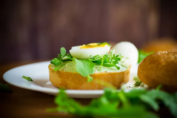 Hausgemachtes Brötchen Mit Käseaufstrich Frischem Rucola Und Gekochtem Einem Teller — Stockfoto