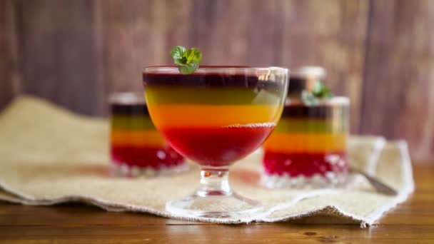 Sweet multi-colored fruit puff jelly in a glass cup — Stock Video