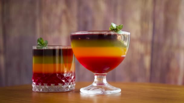Słodka wielokolorowa galaretka owocowa w szklanym kubku — Wideo stockowe