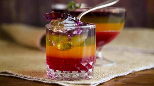 Sweet multi-colored fruit puff jelly in a glass cup — Stock Video