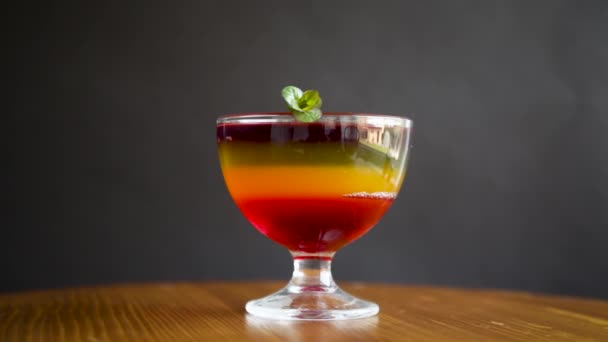 Sweet multi-colored fruit puff jelly in a glass cup — Stock Video