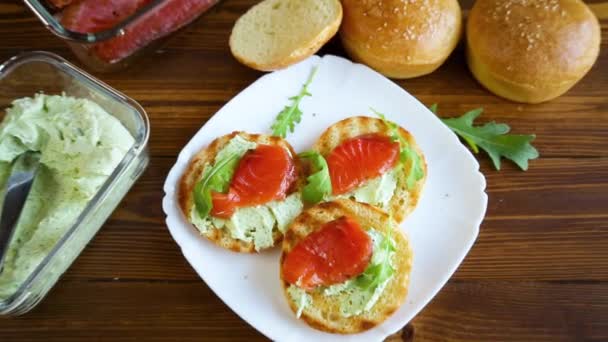 Σάντουιτς με τηγανητό ψωμάκι, τυρί και κόκκινο ψάρι σε πιάτο — Αρχείο Βίντεο