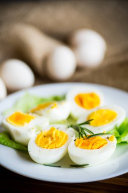 Tahta bir masada salata yapraklı haşlanmış yumurta.