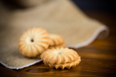 Tahta bir masanın üzerinde yoğunlaştırılmış sütle birlikte çıtır çıtır kurabiyeler.