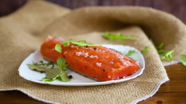 Pedaço de peixe vermelho salgado com diferentes temperos e ervas em um prato — Vídeo de Stock