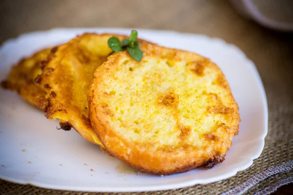 丸いパンは木のテーブルの上の皿の上でバターで揚げたクルトン — ストック写真