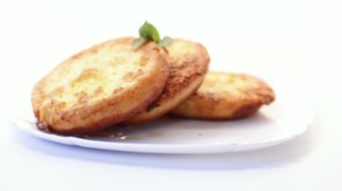 Tabakta hamurda kızartılmış yuvarlak ekmek parçaları.