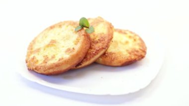 Tabakta hamurda kızartılmış yuvarlak ekmek parçaları.