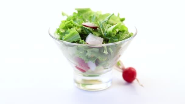 Salada de primavera de verduras iniciais, folhas de alface, rabanetes e ervas em uma chapa — Vídeo de Stock