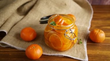 Ahşap bir masada cam bir kavanozda mandalina reçeli