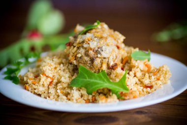 Kaynamış bulgur, sebzelerle ve köftelerle ahşap bir masada inliyor.