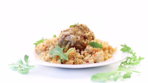 Boiled bulgur groats with vegetables and meatballs in a plate — Stock Video
