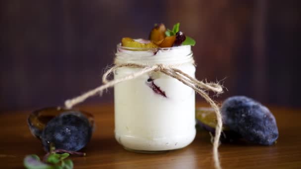 Homemade sweet yogurt with slices of ripe plums in a glass — Stock Video