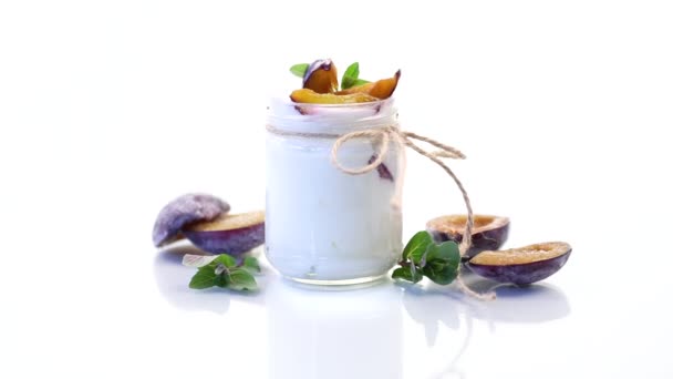 Homemade sweet yogurt with slices of ripe plums in a glass — Stock Video