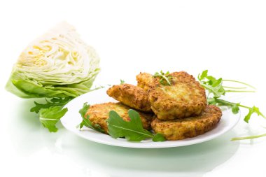 Sebzeli vejetaryen kızarmış lahana krepleri beyaz arka planda izole edilmiş bir tabakta.