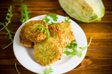 Sebzeli vejetaryen kızarmış lahana krepleri ahşap bir masada tabakta.