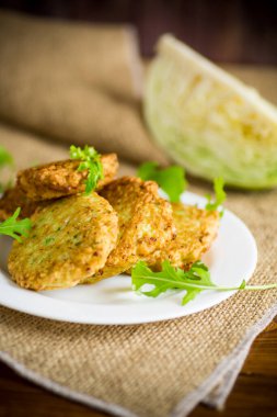 Sebzeli vejetaryen kızarmış lahana krepleri ahşap bir masada tabakta.