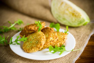 Sebzeli vejetaryen kızarmış lahana krepleri ahşap bir masada tabakta.
