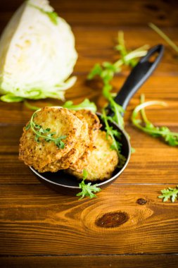 Sebzeli vejetaryen kızarmış lahana krepleri ahşap bir masada tavada.