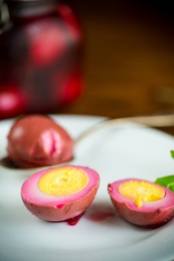 Pancar salamurasında marine edilmiş tavuk yumurtaları ahşap bir masada bir tabakta.
