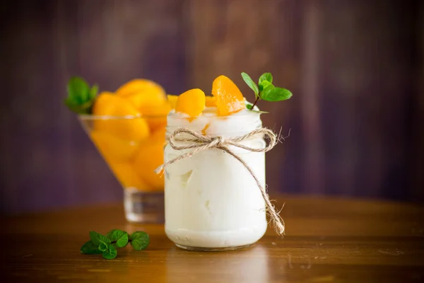 自制甜酸奶 在木制桌子上的玻璃瓶里放上几片腌制桃子 — 图库照片