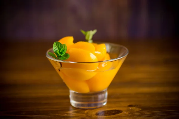 糖果罐头杏仁在糖浆中放在木制桌子上的玻璃碗里 — 图库照片