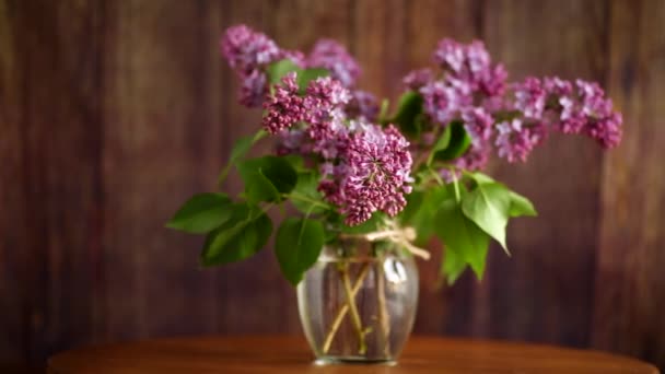 木のテーブルの上の花瓶に美しい花のライラックの花束 — ストック動画