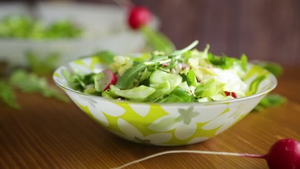 初期の野菜から春のサラダ レタスの葉 木のテーブルの上にプレート内の大根とハーブ — ストック動画