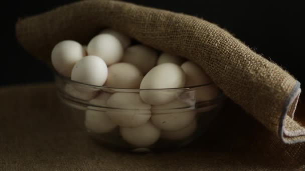 Biologische zelfgemaakte verse eieren in een glazen schaal onder jute — Stockvideo