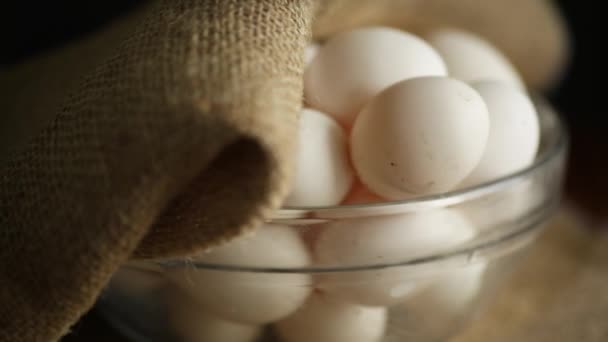 Uova fresche fatte in casa biologiche in una ciotola di vetro sotto iuta — Video Stock
