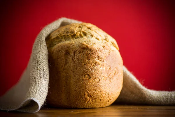 baked homemade bread from a bread machine on a red background