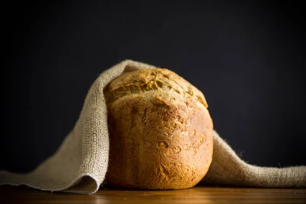 baked homemade bread from a bread machine on a black background