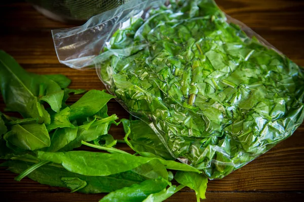 Fresh green sorrel in a vacuum bag, in a colander — Stock Photo, Image