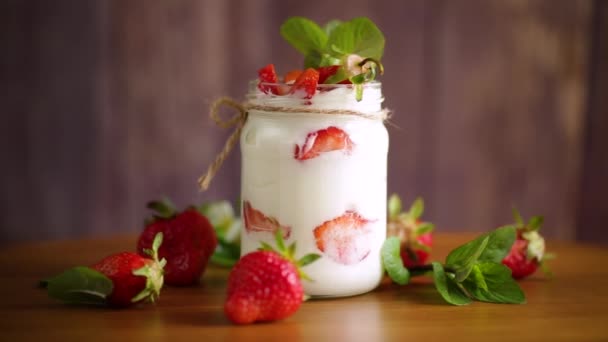 Süßer hausgemachter Joghurt mit reifen frischen Erdbeeren im Glas — Stockvideo