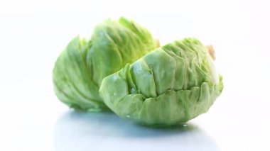 Erken yeşil lahana, beyaz arka planda yarı yarıya sallanır.