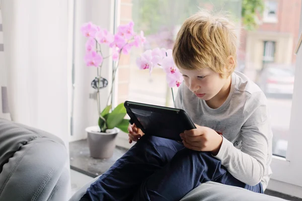 Boy sitting near window — Stock Photo, Image