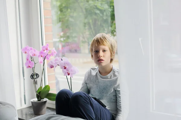 Chlapce, který seděl u okna — Stock fotografie