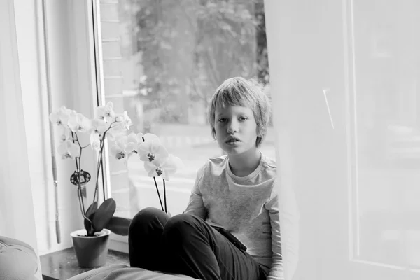 Boy sitting near window — Stock Photo, Image