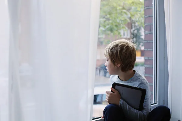 Junge sitzt am Fenster — Stockfoto