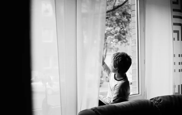 Мальчик, сидящий у окна — стоковое фото